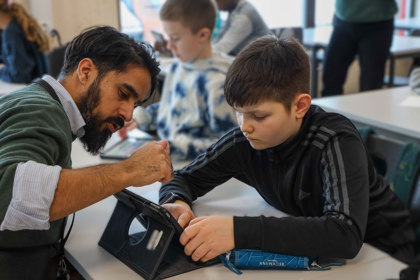 En lærer og en elev leser på læringsbrettet. 