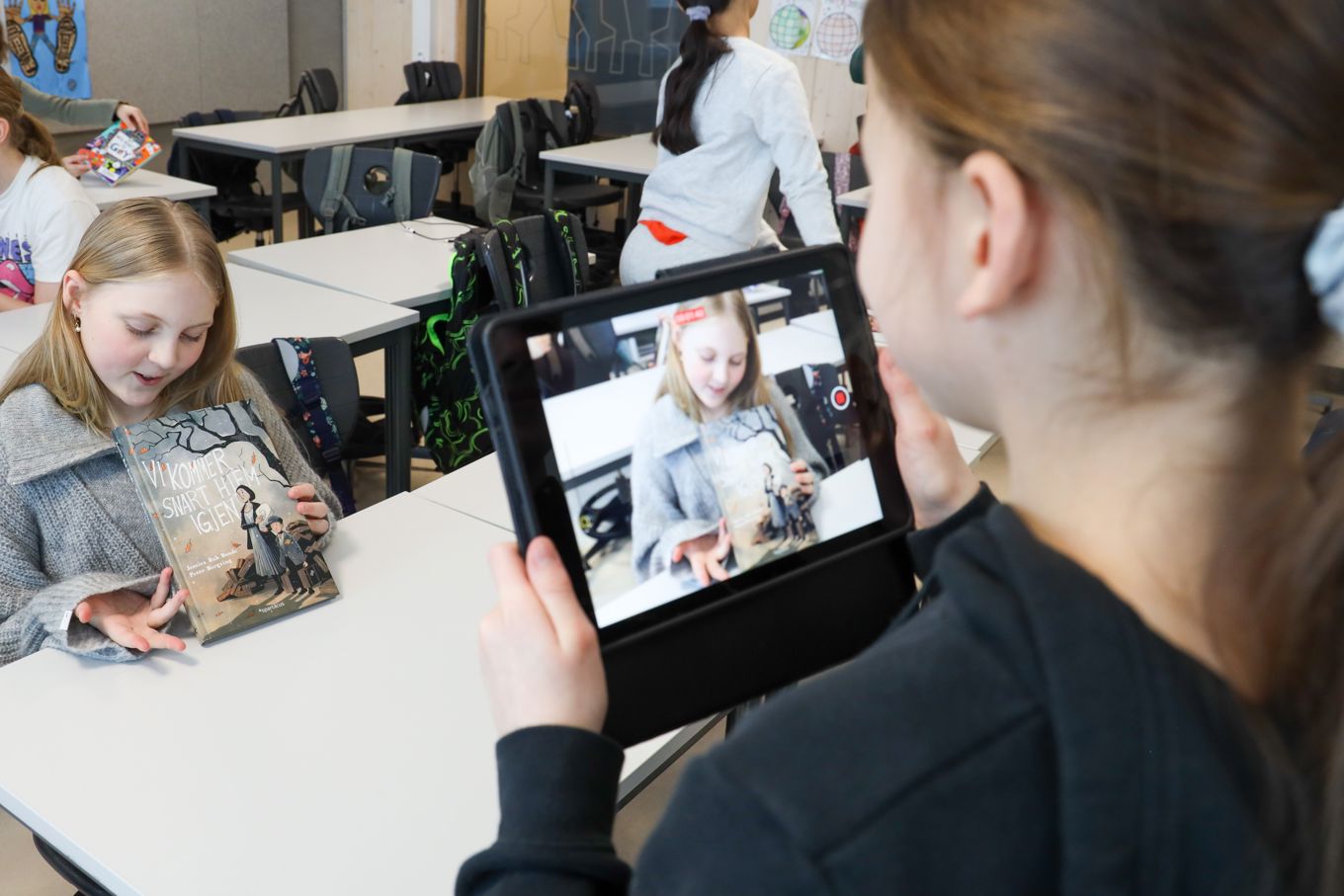 En elev som filmer en annen elev som forteller om boka hun har lest.