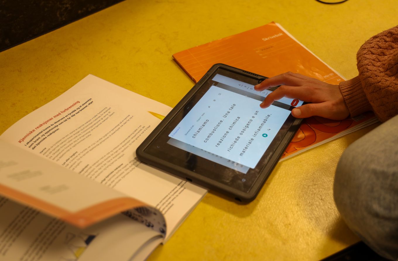 En elev som oversetter tekst fra en lærebok med læringsbrettet
