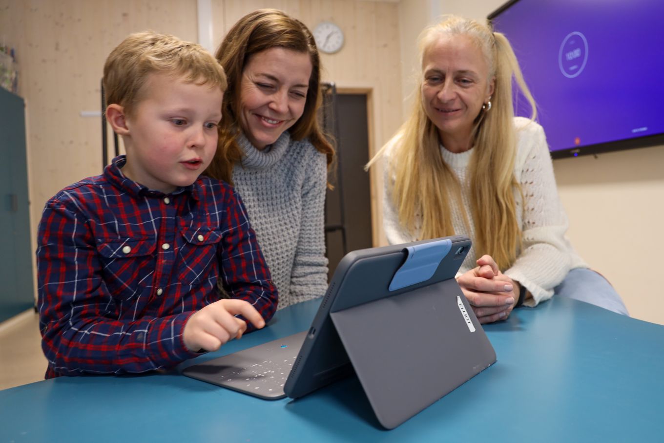 En elev, en mor og en lærer ser på læringsbrettet