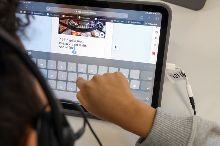 En elev bruker diktering til å skrive en tekst på læringsbrettet