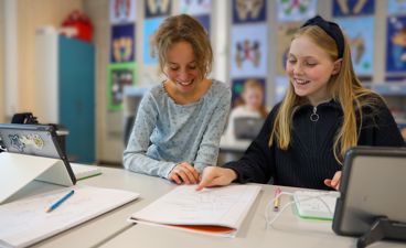 To elever som jobber med skrivearbeid.