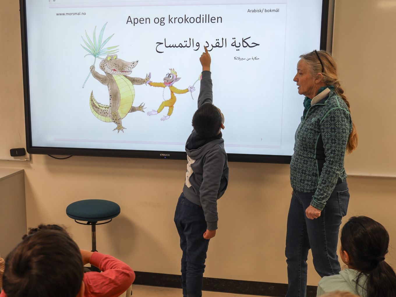 Lærer og elev jobber med eventyr på to språk